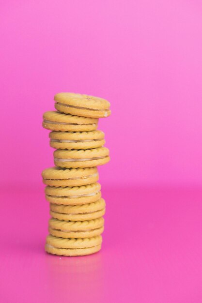 Foto stapel koekjes op een roze achtergrond.