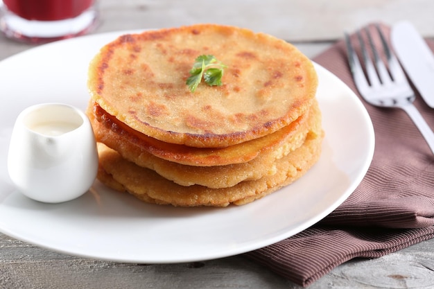Stapel maïs tortillas met vulling en een glas sap op een houten tafel achtergrond