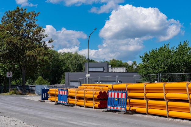 Stapel oranjegele PVC-buisleidingen langs de weg