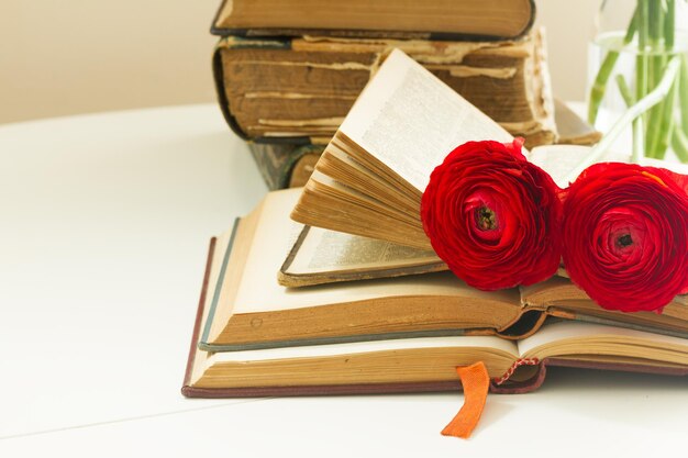 Stapel oude boeken met rode bloemen