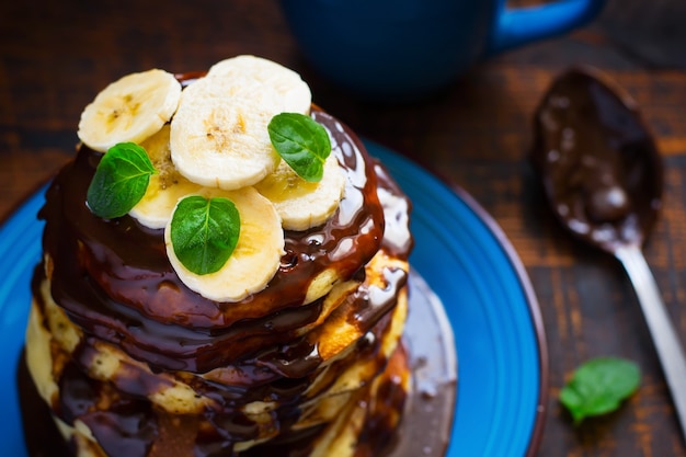 Stapel pannenkoeken met chocolade en banaan.