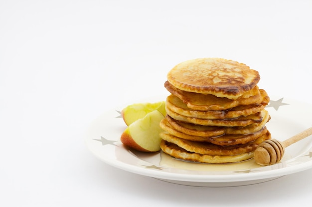 Stapel pannenkoeken met honing op een bord