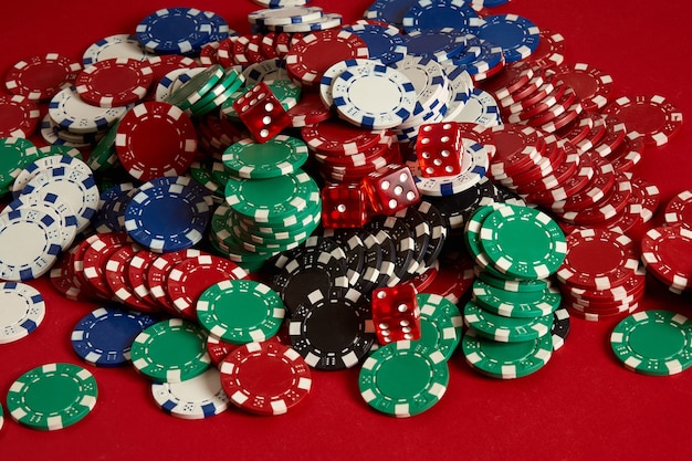 Stapel pokerfiches op rode achtergrond bij casino