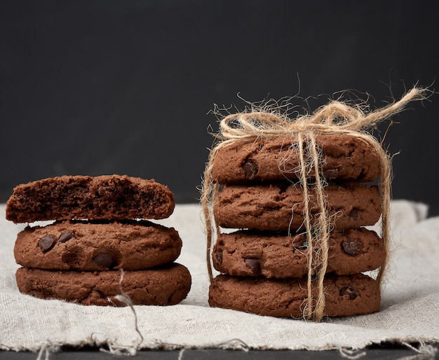 Stapel ronde chocoladeschilferkoekjes die met een kabel op een zwarte raad worden gebonden