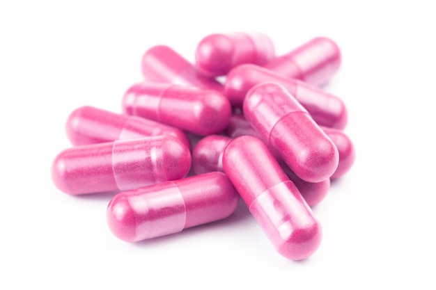 Stapel roze biologische capsules geïsoleerd op een witte achtergrond close-up met selectieve focus