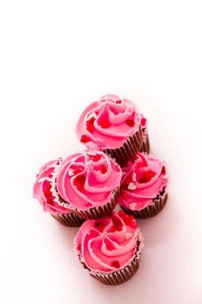 Stapel roze cupcakes met verlovingsring bovenop.