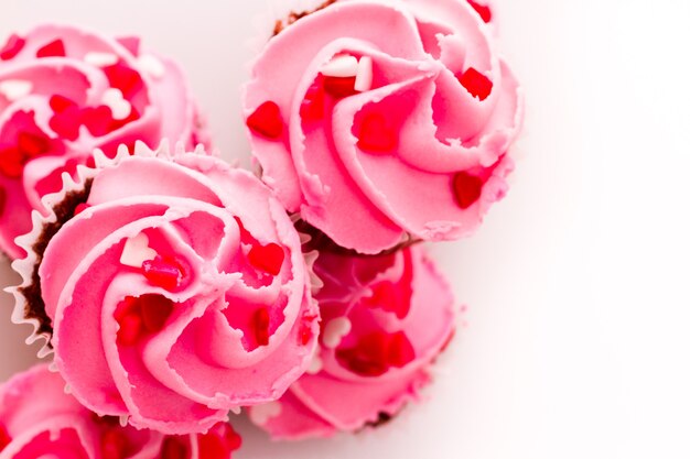 Stapel roze cupcakes met verlovingsring bovenop.