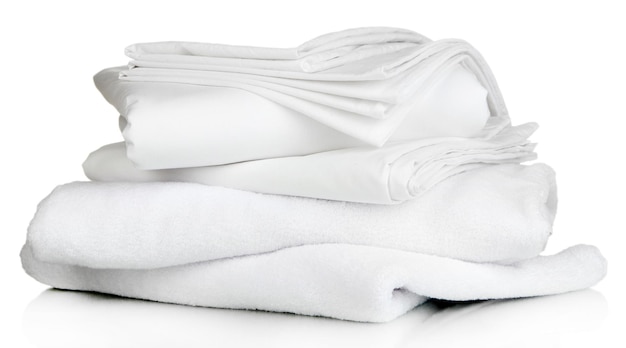 Foto stapel schone beddengoed lakens en handdoeken geïsoleerd op wit
