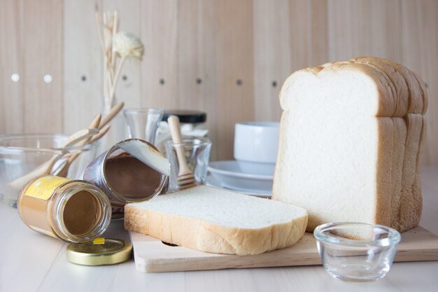 Stapel segment Verse geurige brood op hakblok. koffiekopje en keuken ware gezet op houten tafel.