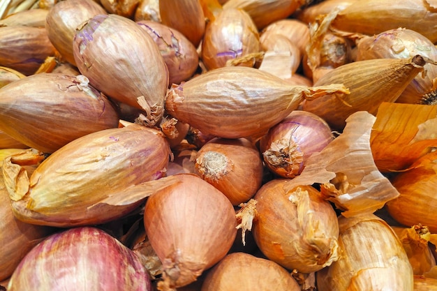 Stapel sjalotten op een marktkraam