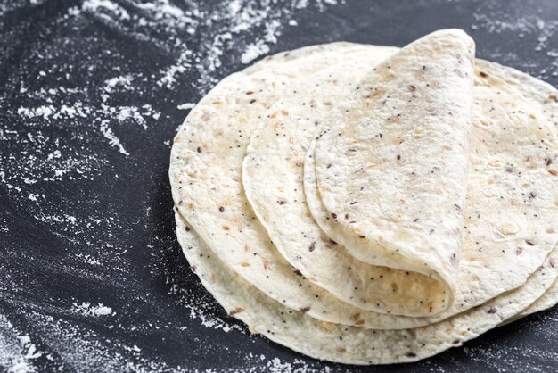 Stapel tortilla's op een zwarte ondergrond