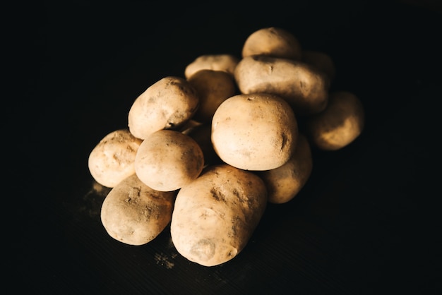 Stapel van aardappelen gerangschikt op zwart.