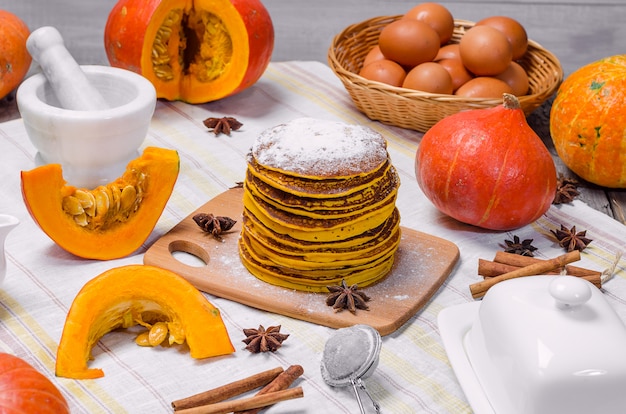 Stapel van eigengemaakte pompoen punkcakes met poedersuiker bovenop op een lichte achtergrond.