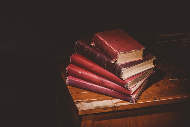 Stapel van oude boeken op rot bureau, uitstekende toon
