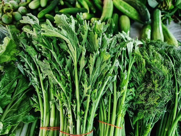 Stapel van verse groene groenten te koop bij marktkraam