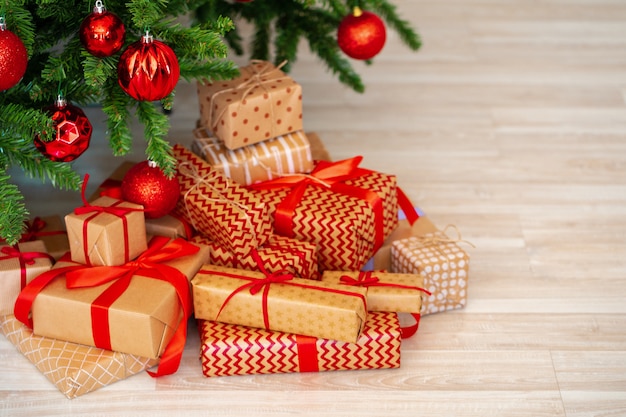 Stapel verpakte cadeautjes onder de kerstboom