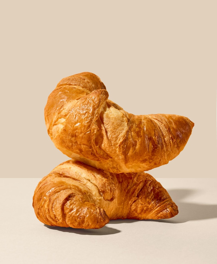 Foto stapel vers gebakken croissants op beige achtergrond