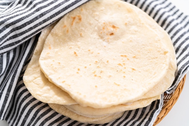 Stapel vers gebakken flatbread verpakt in een theedoek.