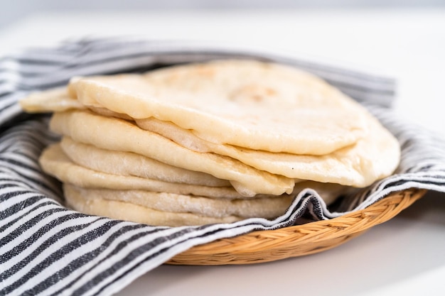 Stapel vers gebakken flatbread verpakt in een theedoek.