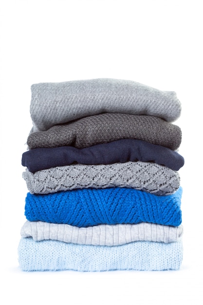 Stapel verschillende sweaters geïsoleerd op wit