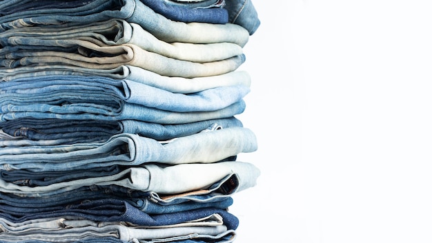 Stapel verschillende tinten blauwe jeans Jeans gestapeld geïsoleerd op witte achtergrond Blauwe denim jeans textuur banner met kopie ruimte voor tekst ontwerp achtergrond Canvas denim mode textuur