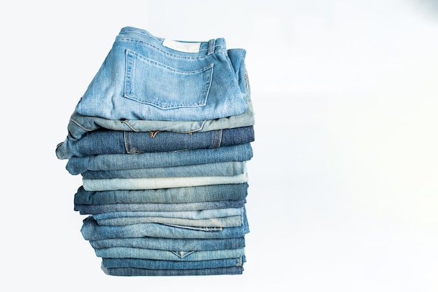 Stapel verschillende tinten blauwe jeans Jeans gestapeld geïsoleerd op witte achtergrond Blauwe denim jeans textuur banner met kopie ruimte voor tekst ontwerp achtergrond Canvas denim mode textuur