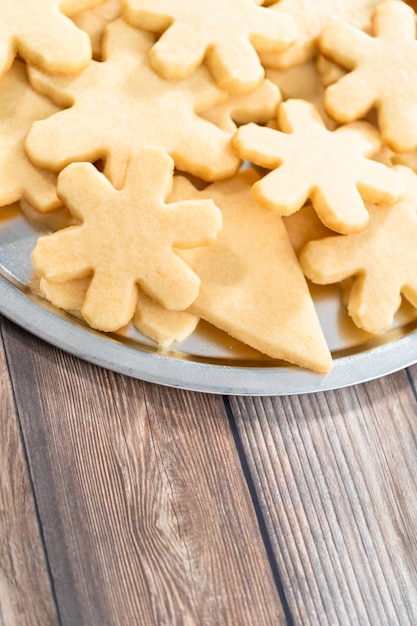 Stapel versgebakken suikerkoekjes in sneeuwvlokvorm.