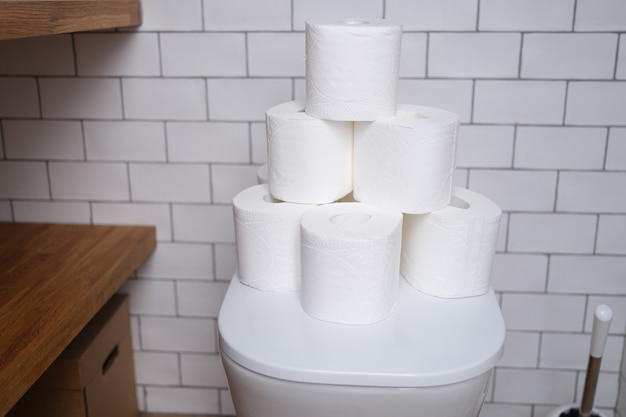 Stapel wc-papier staat op wit toilet in de badkamer close-up