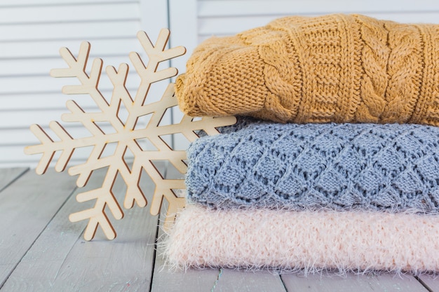 Stapel witte gezellige gebreide sweaters op een houten tafel