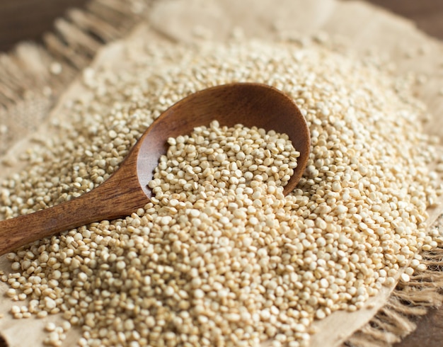 Stapel Witte Quinoa met een lepel op een houten tafel