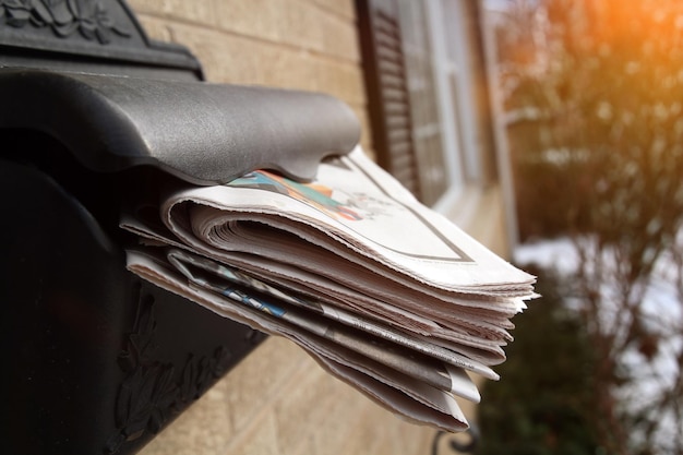 Stapels kranten in een brievenbus buiten