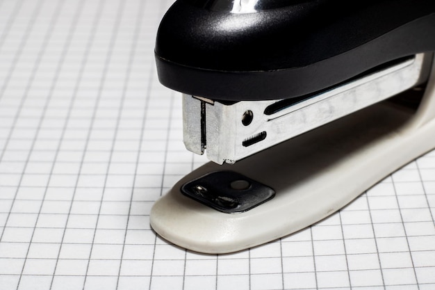 Stapler on the page of notebook in cage