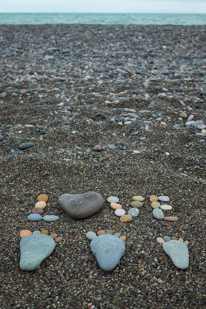 Stappen van man vrouw en kind gemaakt van stenen op zandstrand