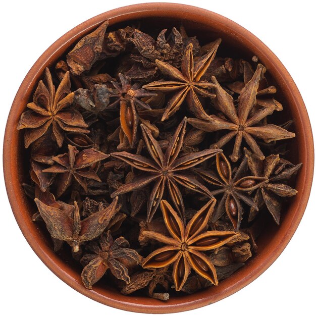 Star anise in a brown ceramic bowl isolated on white background