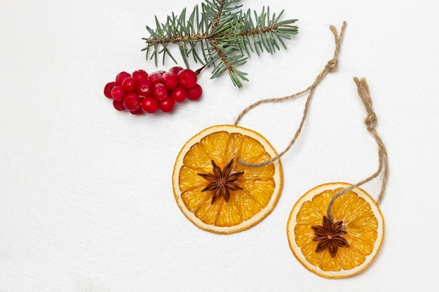 마른 오렌지 조각에 있는 스타 아니스는 테이블에 있는 가문비나무와 붉은 열매의 장식입니다.