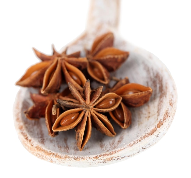 Star anise in wooden spoon, isolated on white