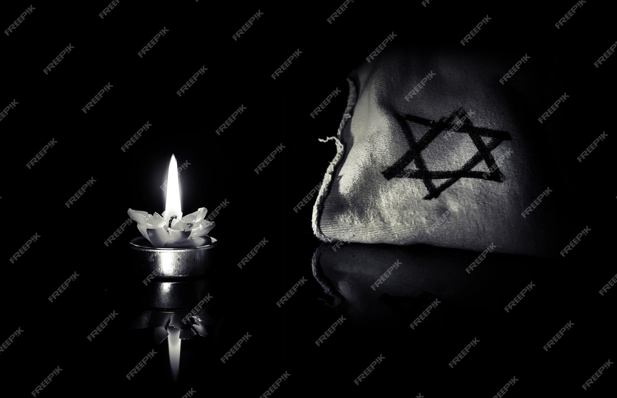 Premium Photo | The star of david and candle stands on the table on a black  background in memory of the victims of the holocaust and genocide black  white photo