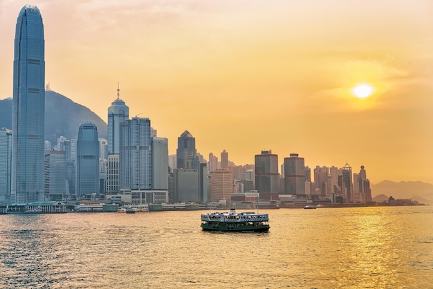 Star ferry at the Victoria Harbor of HK at sundown. View from Kowloon on Hong Kong Island.