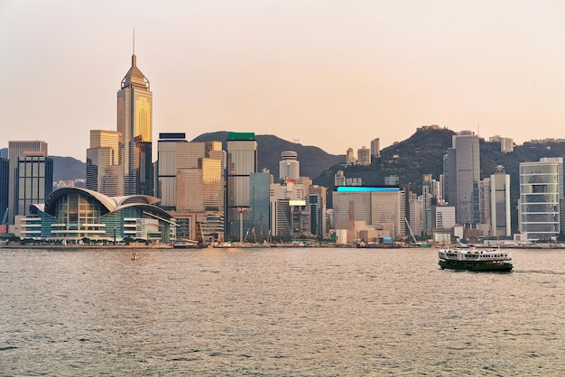 Star ferry at the Victoria Harbor of HK at sundown. View from Kowloon on Hong Kong Island.