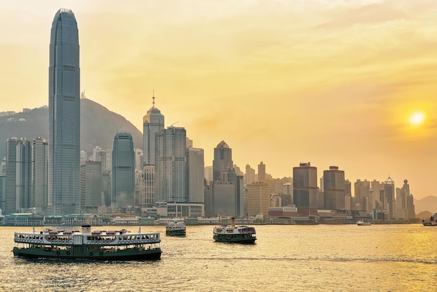 Photo star ferry at victoria harbor in hk at sundown. view from kowloon on hong kong island.