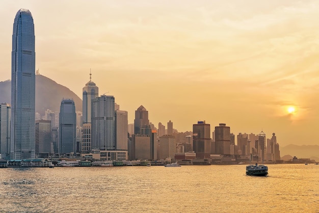 Star ferry at Victoria Harbor in Hong Kong at sundown. View from Kowloon on HK Island.