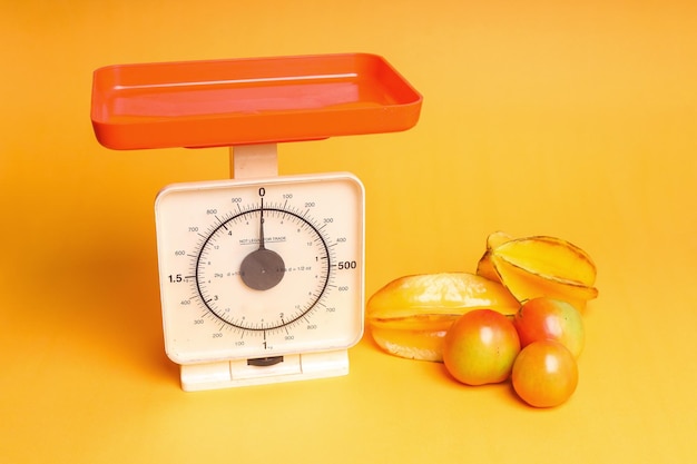 Star fruits tomatoes and weighing scales as part of healthy calorie controlled diet