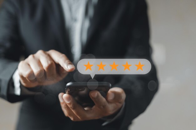 Foto indagine sulla soddisfazione dell'icona stellare imprenditore dal dito allo smartphone con icone a cinque stelle ranking di business feedback rating indagine positiva