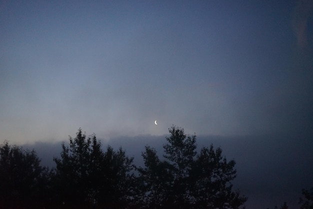 A star is visible above the clouds at night.