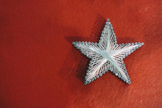 Photo a star made from steel nails and string on red background