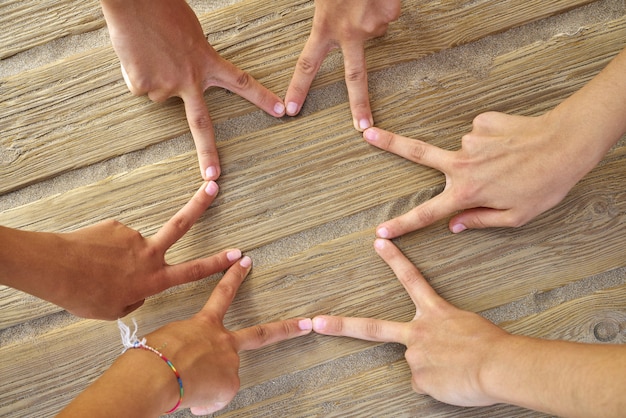 Photo star shape with six hand fingers on a beach