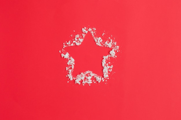 Star and snow on red background. Christmas composition.