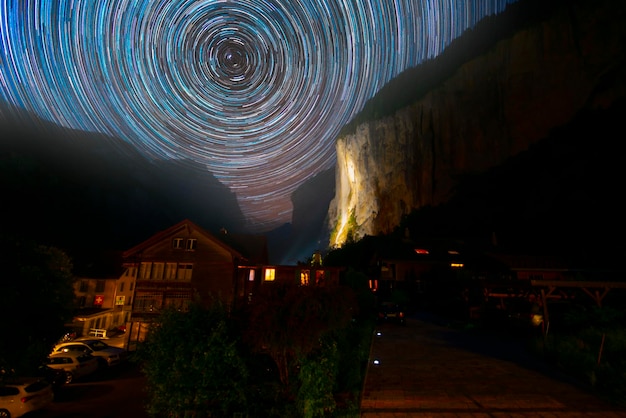 star trails in the sky above a house