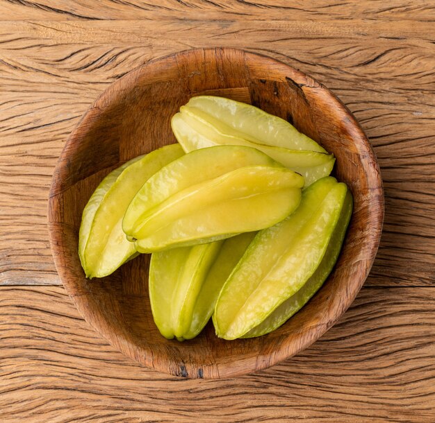 Starfruits in a bowl over wooden table