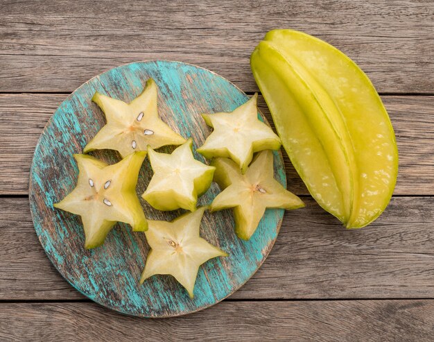 Starfruits met plakjes op een bord boven houten tafel